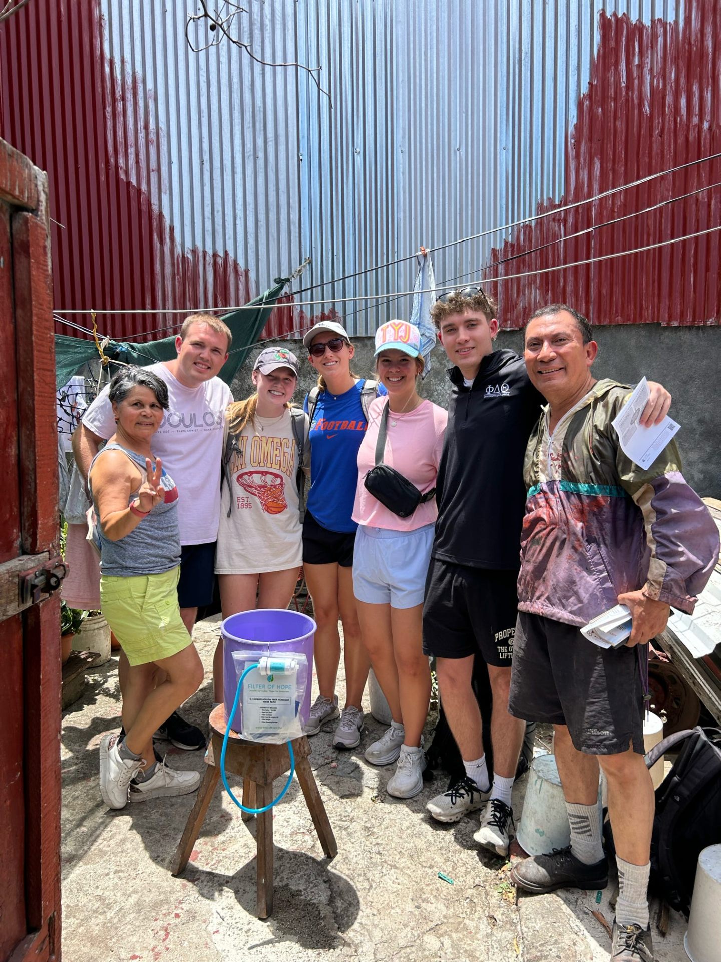 Branden Pearson with a family and the Filter of Hope team after installing a ceramic water filter in Central America